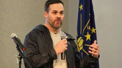 Anthropology faculty member speaks into a microphone