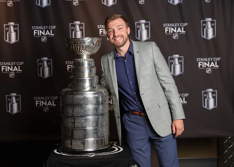 Portrait of USI sport management graduate Adam Newman with the Stanley Cup