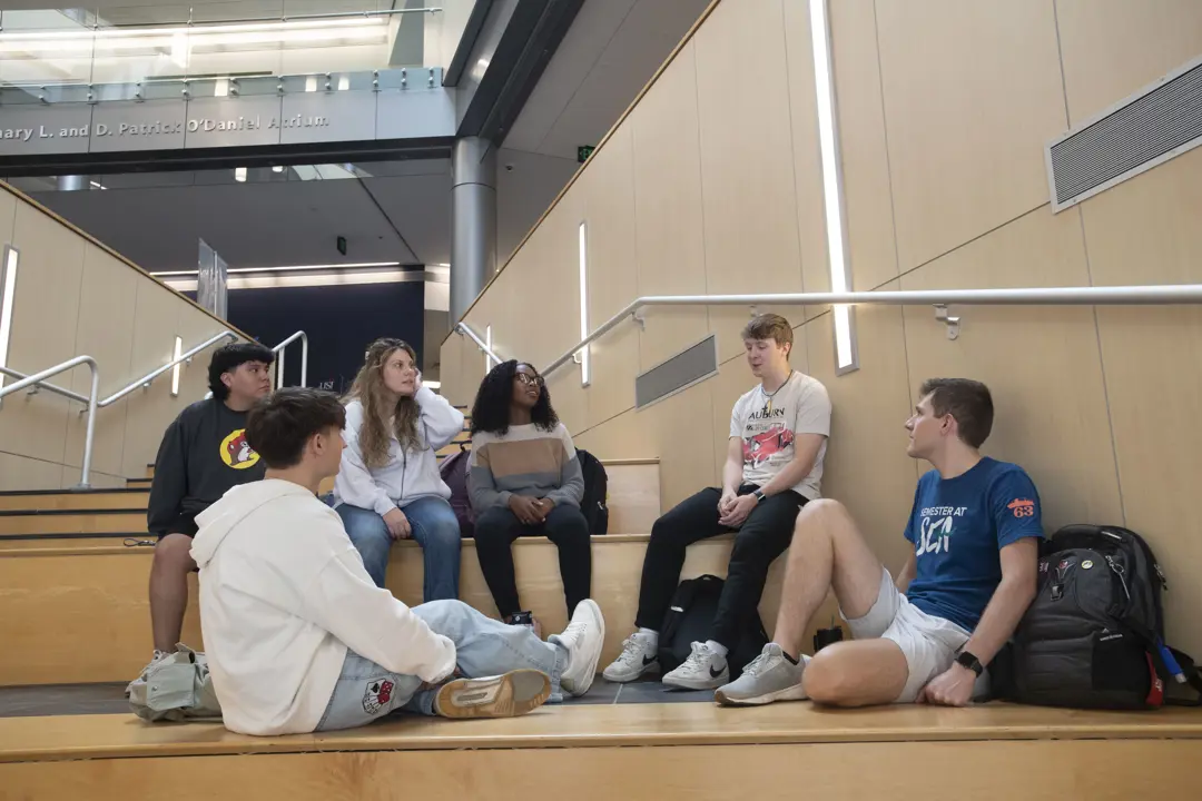 Students talk on the stairs of the Business and Engineering Center Atrium